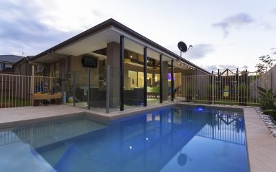 Swimming pool and outdoor entertaining area in stylish home at dusk